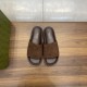 Gucci Brown Suede Slide Sandals Overhead View Direct overhead view of Gucci brown suede slide sandals on wooden surface