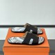 Hermes Izmir Black Leather Printed Sandals - Angled View Hermes Izmir Black Leather Printed Sandals angled view on an orange box