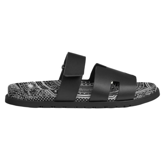 Side profile of Hermes Chypre Astrologie black leather sandals showing black straps and patterned footbed