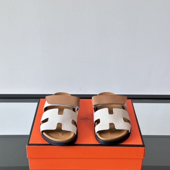 Hermes Chypre Sandals In Grey And Brown Front View Frontal view of Hermes Chypre Sandals In Grey And Brown highlighting the H-motif upper straps