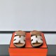 Hermes Chypre Sandals In Grey And Brown Front View Frontal view of Hermes Chypre Sandals In Grey And Brown highlighting the H-motif upper straps
