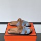 Hermes Chypre Sandals In Blue And Brown Three Quarter Angle Hermes Chypre Sandals In Blue And Brown angled pair resting on an orange box
