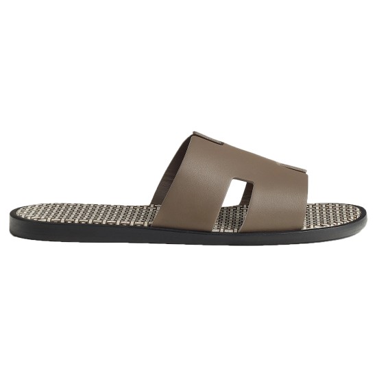 Profile view of Hermes Izmir Sandals in etoupe leather showcasing the strap and patterned sole in orange