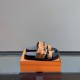 Hermes Jackson Brown Suede Sandals on Box in brown and silver Angled view of Hermes Jackson brown suede sandals resting on an orange presentation box in brown and silver