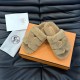 Hermes Chypre Brown Shearling Sandals Angled View Angled top view of Hermes Chypre brown shearling sandals resting on orange box with accessories