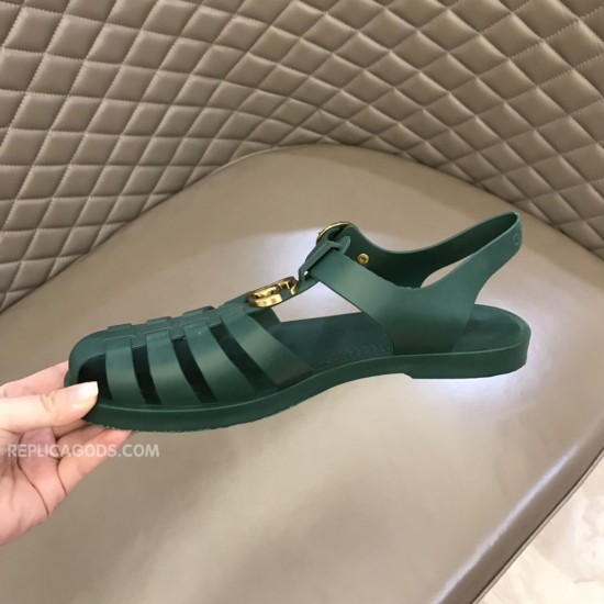Gucci Green Rubber Sandal Medial View Handheld medial view of Gucci green rubber sandal showing toe cage
