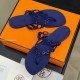 Hermès Island Violet Iris Sandals Angled View Angled perspective view of Hermès Island Violet Iris sandals resting on packaging materials