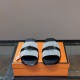 Frontal view of Hermes Gabriel grey and black sandals highlighting upper straps and hardware