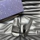 Gucci Black Rubber Slide Sandals Overhead Angle Top down perspective of one black rubber slide sandal beside a patterned storage box