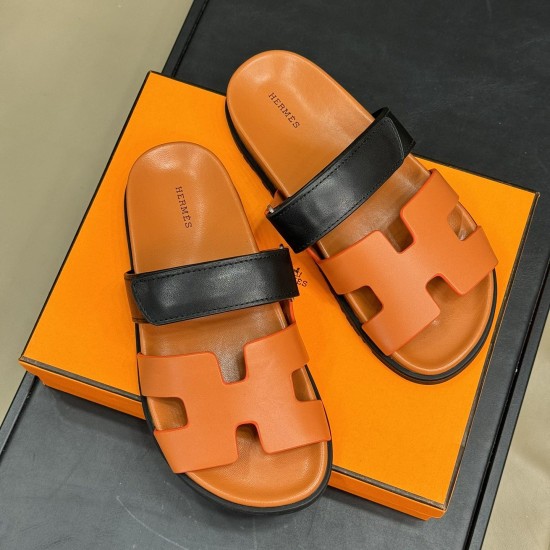 Hermes brown and black sandals top view on box Top-down view of Hermes brown sandals resting on an orange box displaying branding on the footbeds in brown and black