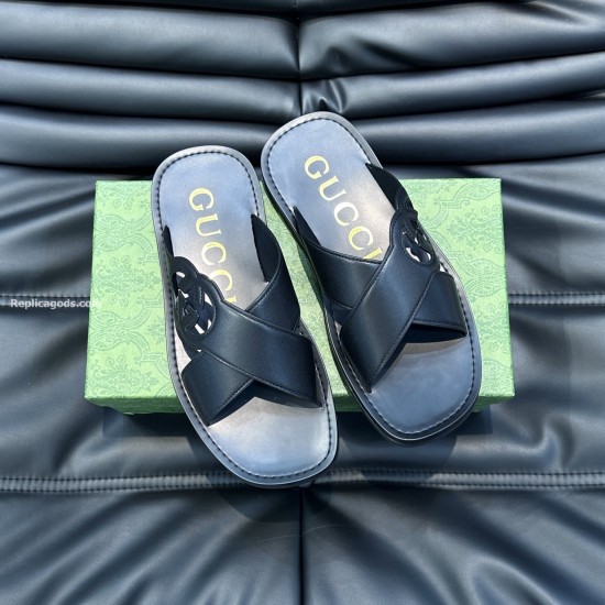 Gucci Black Leather Sandals Flat Top View Gucci black leather sandals arranged flat on a dark textured surface above a green box