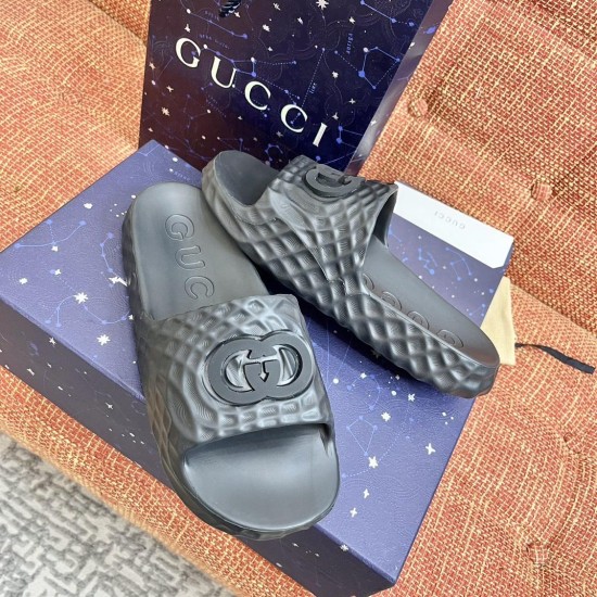 Gucci black slide sandals packaging and angled view Gucci black slide sandals displayed on patterned luxury packaging boxes
