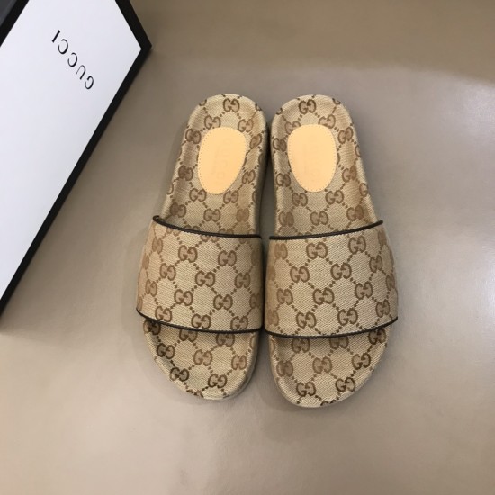 Top-down view of the pair of beige and brown monogram slide sandals next to a brand box
