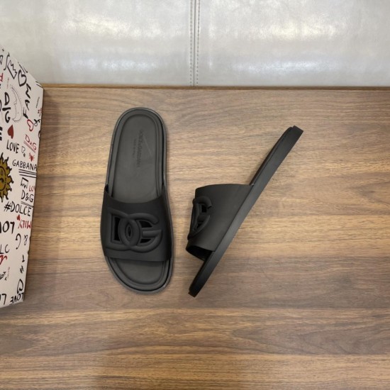 Top and angled view of Dolce & Gabbana black rubber slides next to printed packaging box