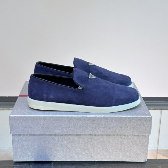 Three-quarter pair view of Prada Men's blue suede slip-on shoes on a grey box in blue and white