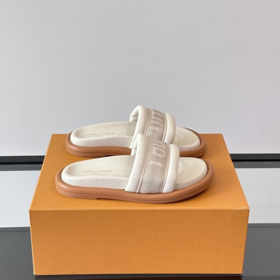 Angled view on orange box of white ecru L mules Angled view of the white ecru L mules resting on a signature orange presentation box
