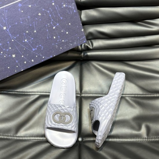 Top and side angle of Gucci grey rubber slide sandals with storage box Gucci grey rubber slide sandals positioned next to a patterned presentation box