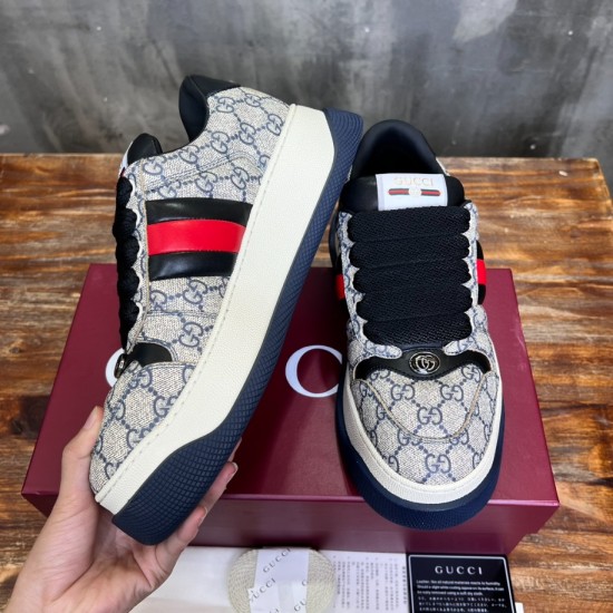 Gucci Screener Web Trainers Handheld Angle in beige and blue Handheld side and front angle of Gucci Screener Web Monogram Canvas Trainers in beige blue