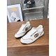 Pair of Gucci white and brown logo trainers resting on wooden surface