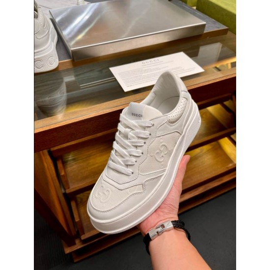 Handheld front-facing angle of Gucci white low-top trainer highlighting toe cap and lacing