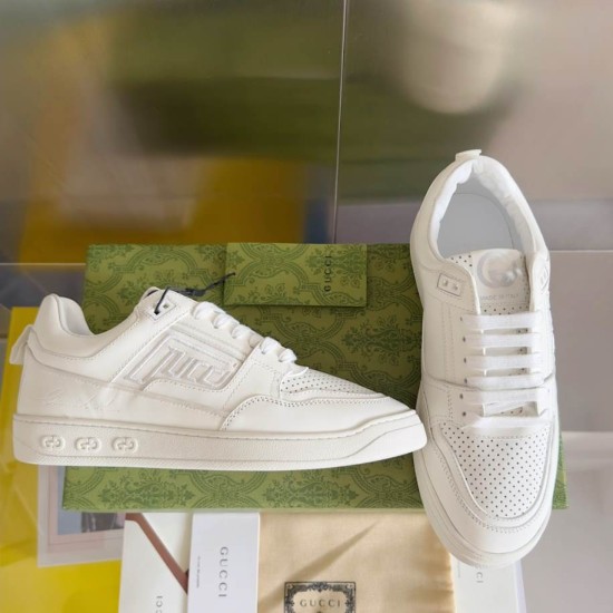 Gucci White Leather Trainers Display View in white and gold Gucci white leather trainers resting against green patterned shoe box in white and gold
