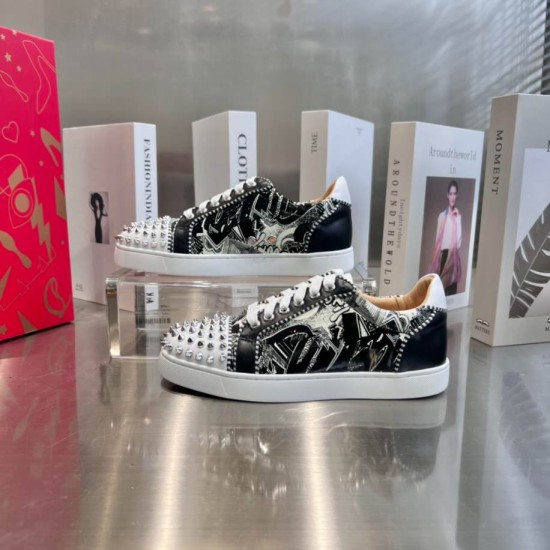 Christian Louboutin Low Top Trainers Display View in black and white Two Christian Louboutin low top spiked trainers arranged on a glass stand in black and white