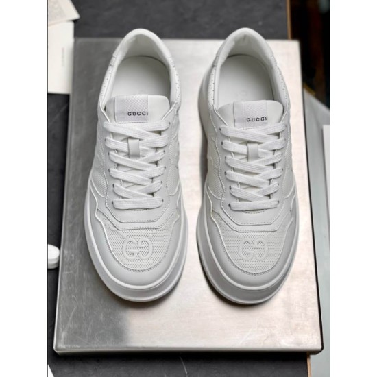 Top-down pair view of Gucci white embossed trainers showing lace closure and tongue branding