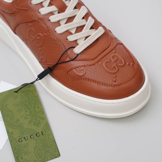 Close-up of Gucci brown embossed leather toe box and off-white laces