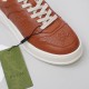 Close-up of Gucci brown embossed leather toe box and off-white laces