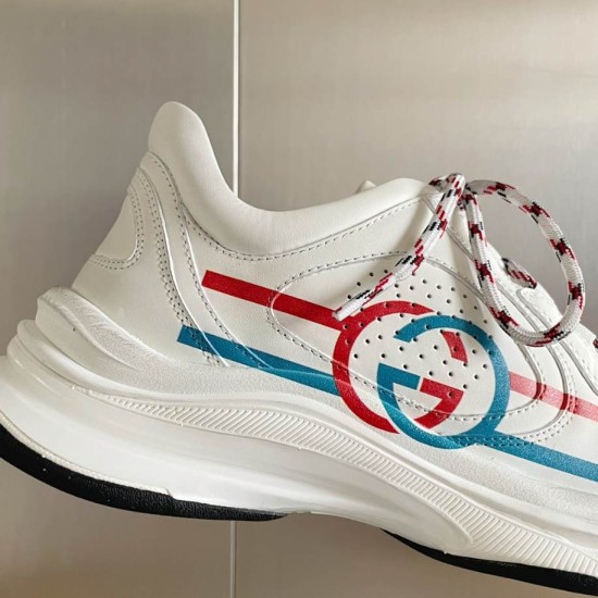 Gucci Run Leather Trainers In White Detail View in white and red Close-up detail of Gucci Run Leather Trainers In White showing perforated leather and Interlocking G logo in white and red