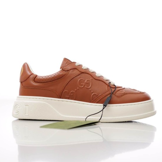 Side view of Gucci brown jumbo GG embossed leather low top trainer