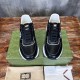 Front view of Gucci black leather low top trainers with white soles on box