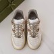 Overhead top-down view of both white and brown Gucci trainers side by side