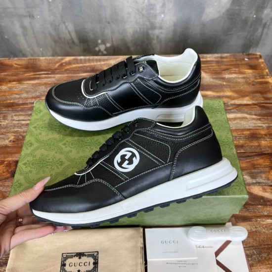 Side view of Gucci black leather trainer held up displaying white midsole and logo