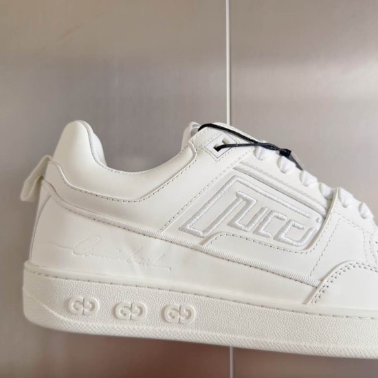 Gucci Leather Trainer Detail View in white and gold Detailed view of white leather upper featuring stitched branding panel and embossed sole motifs in white and gold