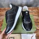 Pair of Gucci black leather trainers resting on green shoe box in black and white