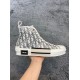 Lateral side profile of Dior B23 high-top white trainer held in hand