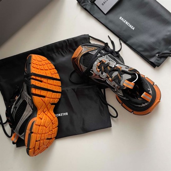 Pair of Balenciaga 3XL trainers showing the bright orange textured tread outsole in black and orange
