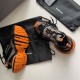 Pair of Balenciaga 3XL trainers showing the bright orange textured tread outsole in black and orange