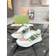 Pair of Gucci white leather trainers with beige GG canvas panels positioned on a glass display surface