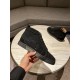 Hand holding Christian Louboutin black embellished high top trainer