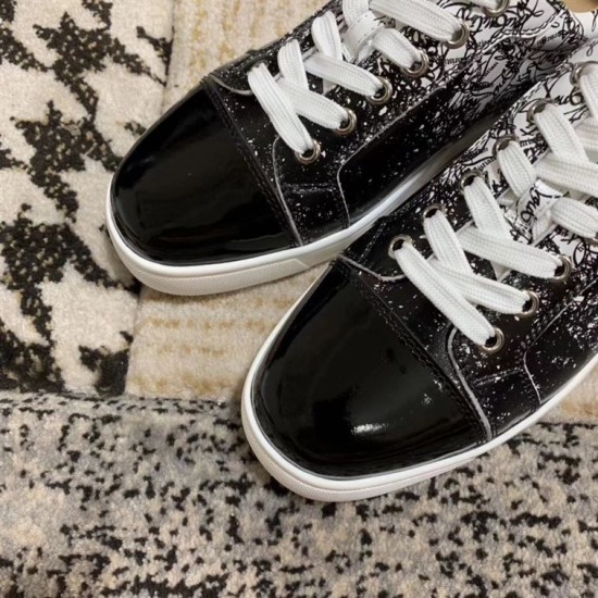 Close-up of the glossy black patent toe cap on Christian Louboutin trainers in black and white