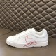 Side profile of Christian Louboutin white script trainer resting on bench seat in white and red