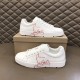 Pair of Christian Louboutin white leather trainers stacked beside shoebox showing script logo in white and red