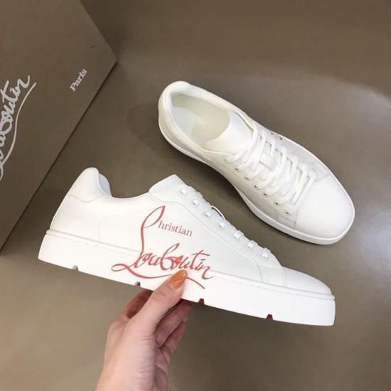 Hand holding Christian Louboutin white trainer showing red script print along side panel