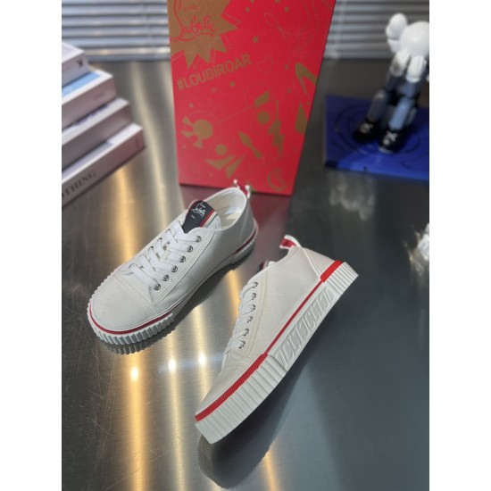 Side elevation of Christian Louboutin white low top trainer on reflective surface in white and red