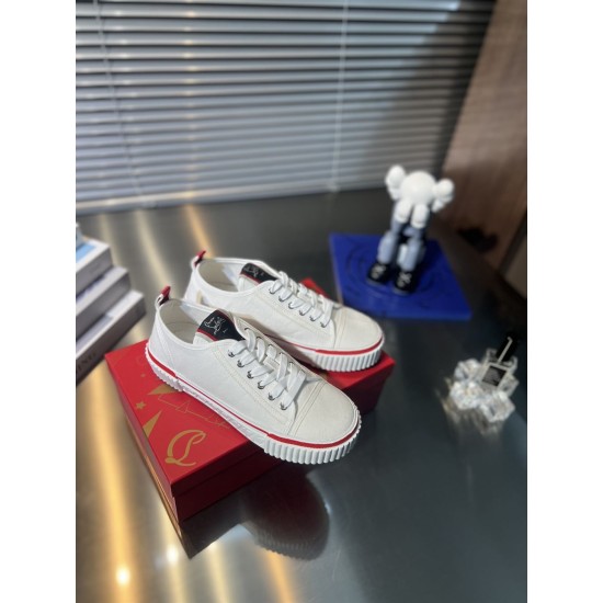 Pair of Christian Louboutin white canvas trainers sitting on a red shoe box