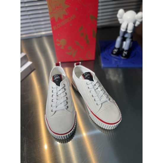 Front angle view of Christian Louboutin white canvas low top lace-up trainers in white and red
