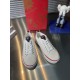 Front angle view of Christian Louboutin white canvas low top lace-up trainers in white and red