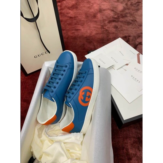 Blue Leather Trainers Angled View in blue and orange Angled view of blue leather trainers showcasing orange side patch and tonal laces